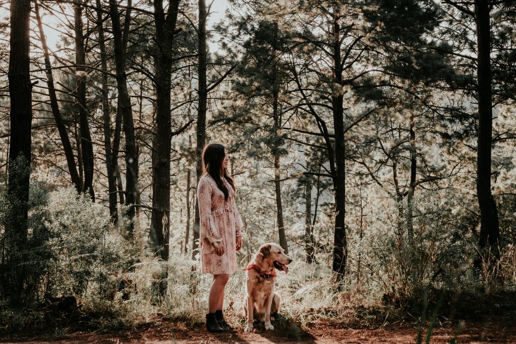 Femme qui promène son chien en forêt
